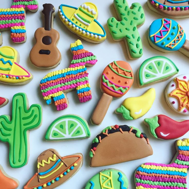 Festive Vibrant Cookie Designs: Intricate Icing on Cacti, Sombreros, Maracas, and Tacos.