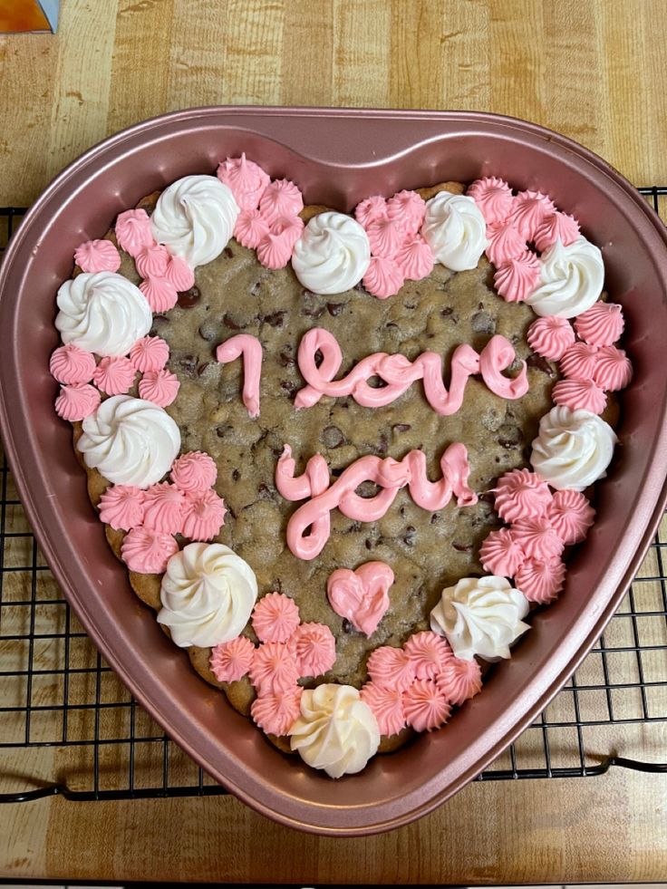 Romantic Heart-Shaped Cookie Cake with Playful Pink and White Frosting for Special Occasions.