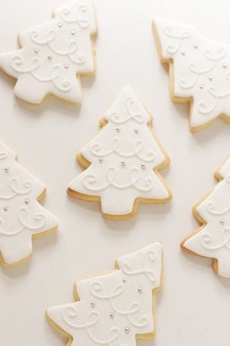 Elegant White Christmas Tree Cookies with Intricate Icing and Sparkling Accents