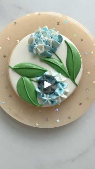 Charming Floral Cake Design with Intricate Blue and Green Icing Elements.