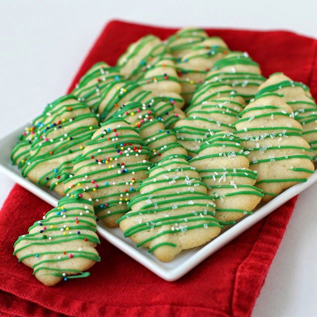 Cheerful Holiday Feast: Festive Green Tree-Shaped Cookies with Vibrant Icing and Sprinkles.