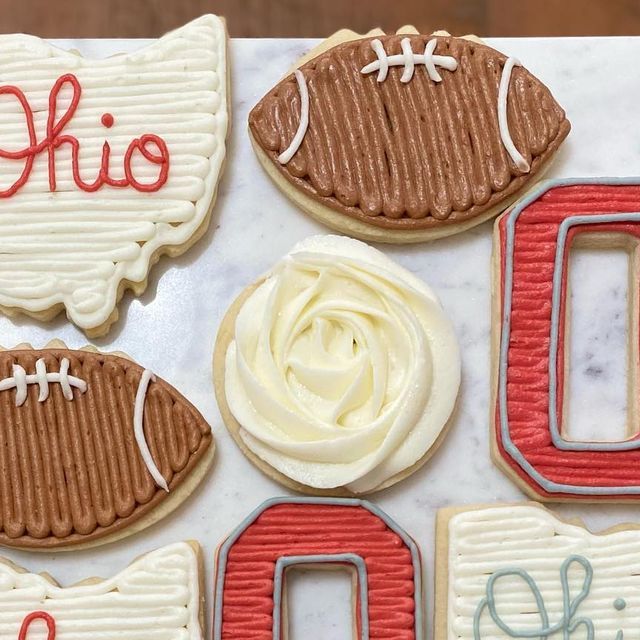 Playful and Elegant Decorative Cookies: Football Shapes and Delicate Rose Icing Designs.