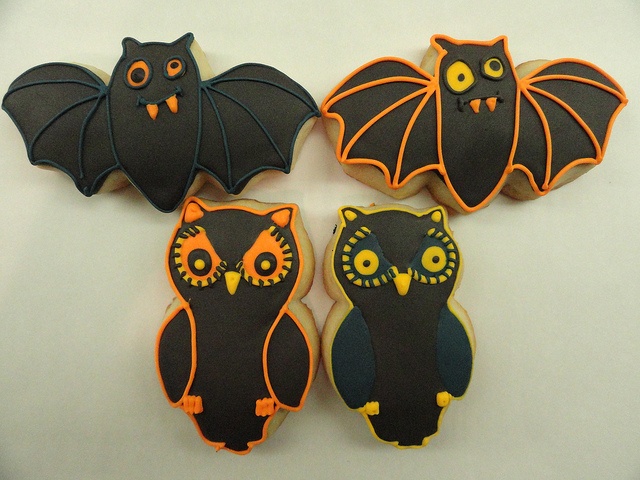 Whimsical Halloween Cookie Designs Featuring Bats and Owls in Black and Orange Icing.