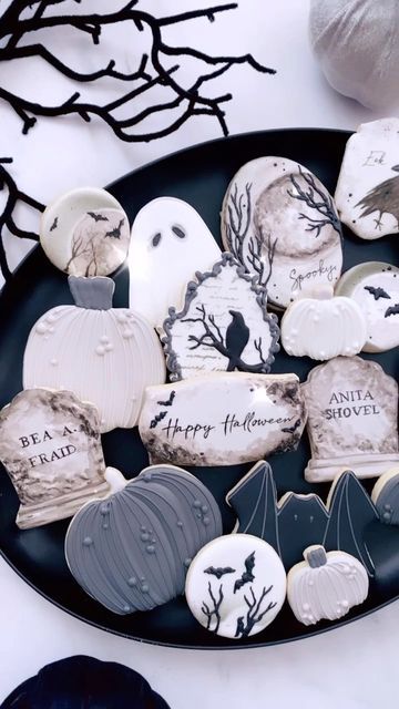 Spooky Halloween Cookies Decorated with Intricate Icing on a Dark Plate.