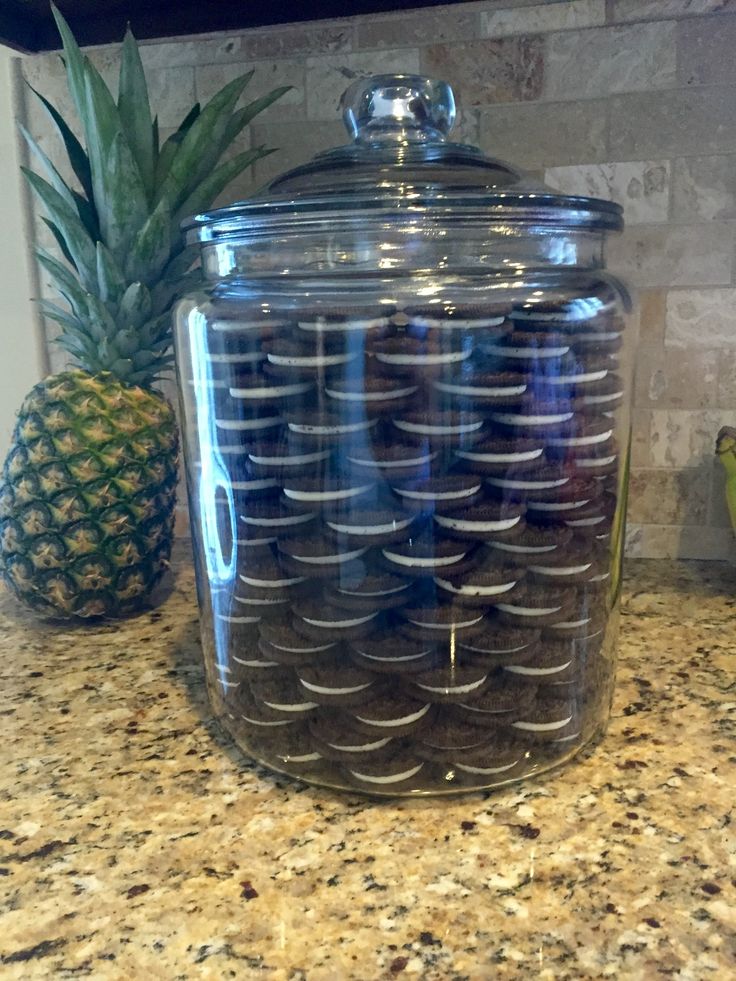 Visually Appealing Transparent Cookie Jar Showcases Layered Chocolate Sandwich Cookies as Decorative Kitchen Element.