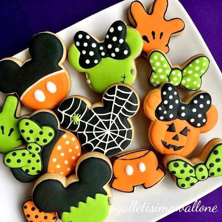 Festive Halloween-Themed Colorful Cookies: Ghostly Mickeys, Pumpkins, and Whimsical Bows.