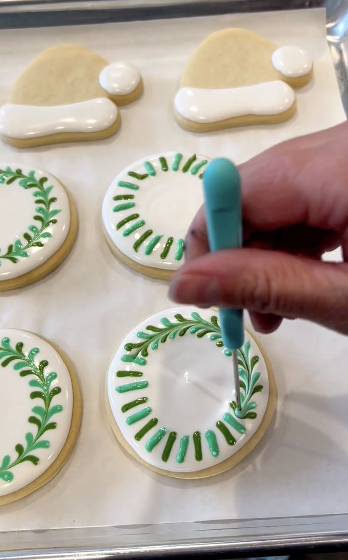 Intricate Green Piping on Smooth White Icing: Elegant Leaf Designs for Festive Cookie Decorations.