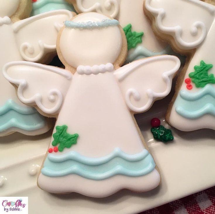 Festive Cookie Design: Charming Angel in Soft Whites and Pastel Blues with Holly and Berries