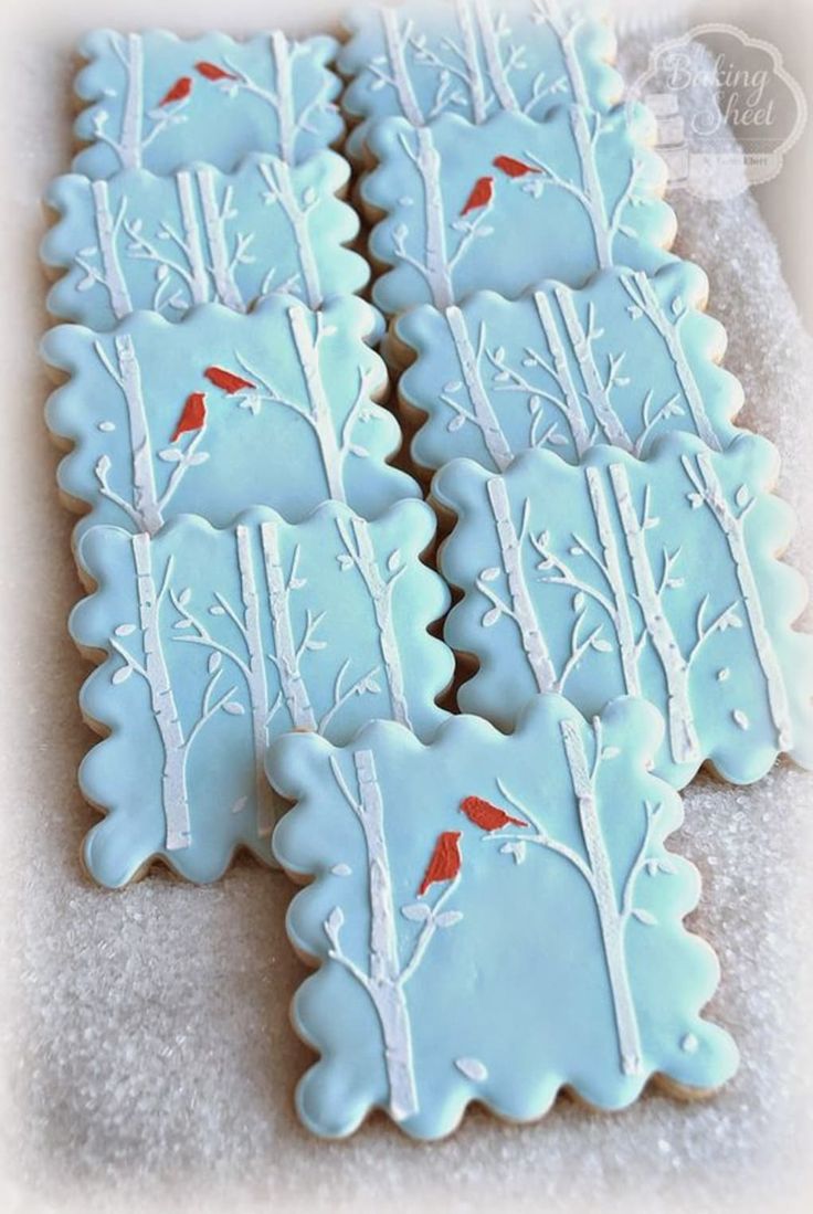 Winter Cookie Design: Soft Blue Background with Delicate White Branches and Vibrant Red Cardinals.