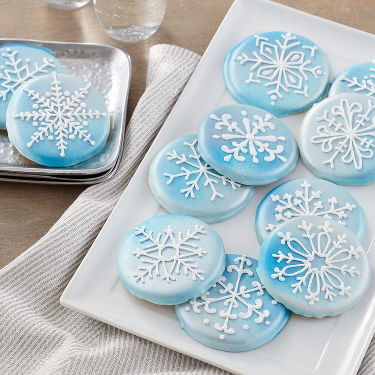 Elegant Winter-Themed Cookies Adorned with Intricate Snowflake Designs in Icy Blue and White.