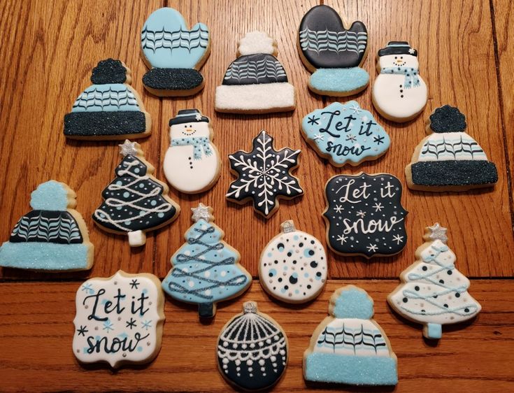 Delightful Winter-Themed Cookies: Snowmen, Trees, Mittens, and Snowflakes in Icy Blue, White, and Black.