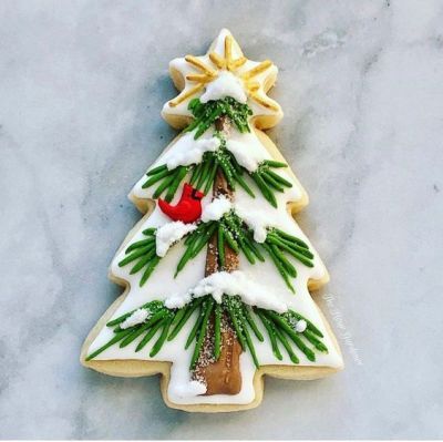 Festive Christmas Tree Cookies with Snowy Icing and a Bright Red Bird Accent.