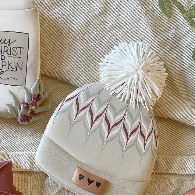 Chic Winter Beanie with Leaf Patterns and Playful Pom-Pom for Trendy Warmth.