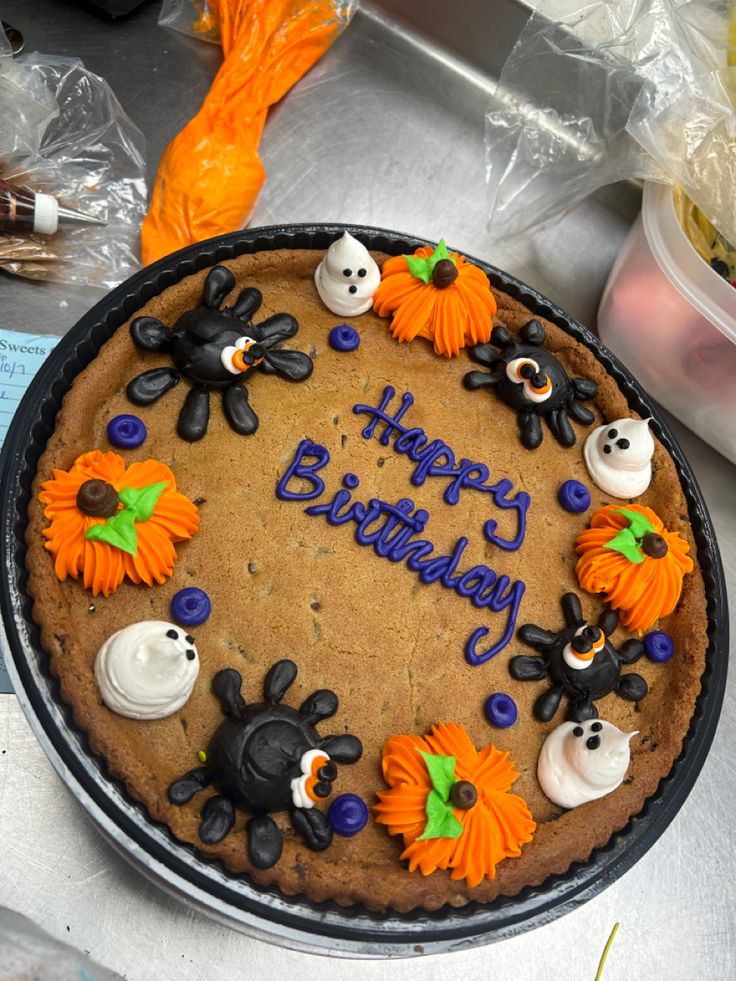 Whimsical Festive Birthday Cake Embellished with Colorful Spider and Pumpkin Icing Designs.