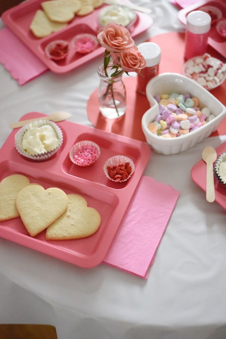 Romantic Pink-Themed Dessert Table with Heart-Shaped Cookies and Rose Petals.