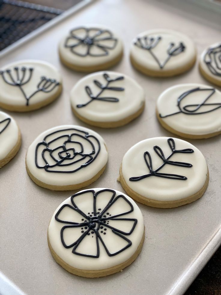 Intricate Floral Cookie Designs with Black Outlines on White Icing