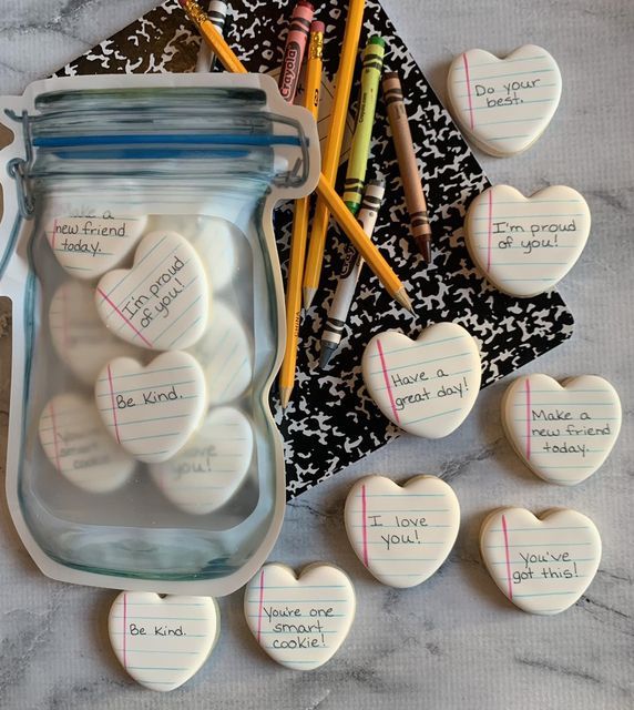 Heart-Shaped Message Stones: Uplifting Phrases for Inspiration Against Colorful Stationery.