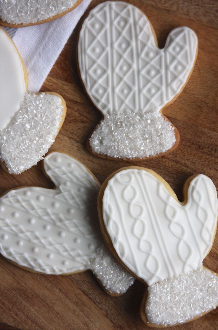 Festive Mitten-Shaped Cookies with Intricate Icing Designs and Sparkling Sugar Accents.