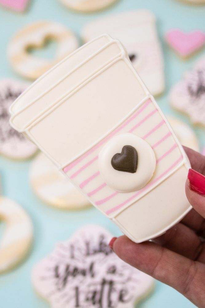 Charming Coffee Cup Cookie Design with Pink Stripes and Heart Accent.