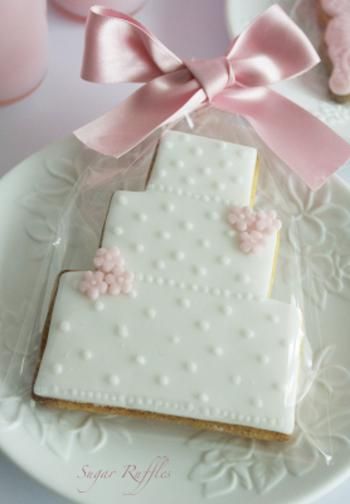 Elegant Wedding Cake-Shaped Decorative Cookie with Pink Accents.