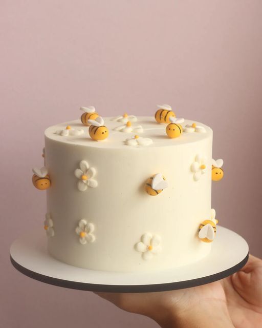 Whimsical Cake Design with Floral Accents and Cheerful Bee Decorations.