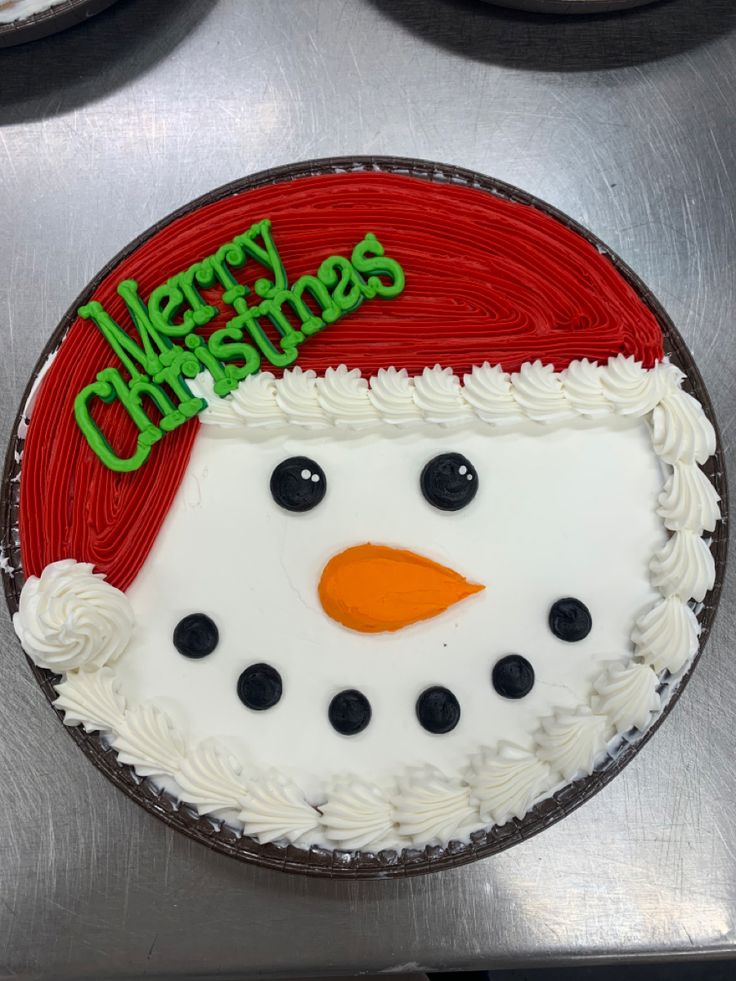 Whimsical Festive Cake Design: Cheerful Snowman with Whipped Cream Snow and Colorful Santa Hat Accents.