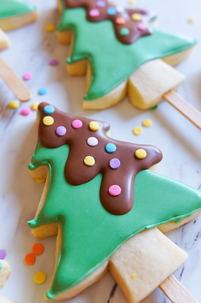 Festive Christmas Tree Cookies: Colorful, Iced Treats on Popsicle Sticks for Holiday Celebrations.