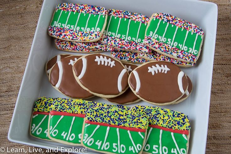 Football-themed decorative cookies: chocolate and green field shapes with colorful sprinkles, ideal for sports events.