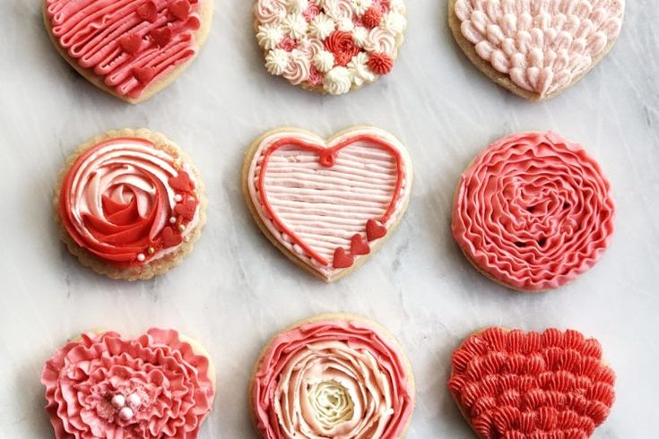 Intricately Iced Heart-Shaped Cookies in Romantic Soft Pink and Rich Red Designs for Celebrations.