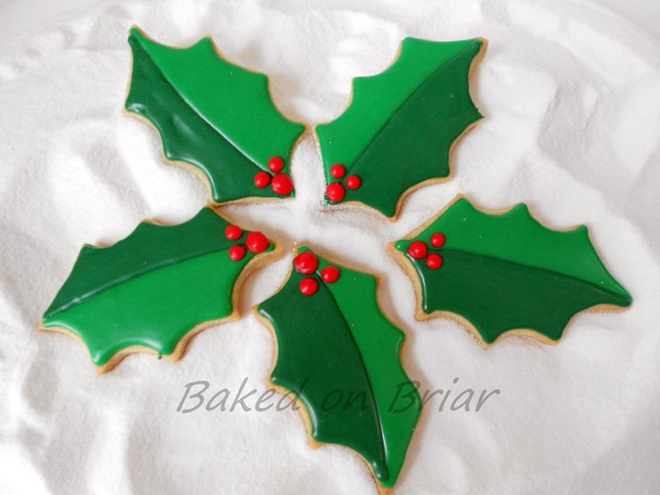 Whimsical Festive Holly-Shaped Cookies with Vibrant Icing and Berry Accents.