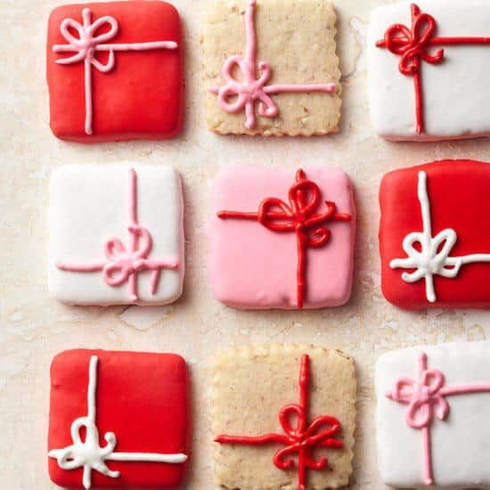 Vibrantly decorated present-shaped cookies bring festive cheer with colorful icing bows and ribbons.