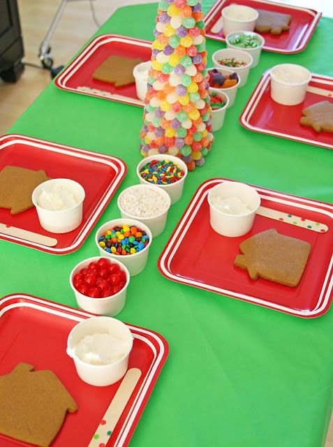 Festive Gingerbread House-Building Dessert Table with Colorful Supplies and Cheerful Decor.