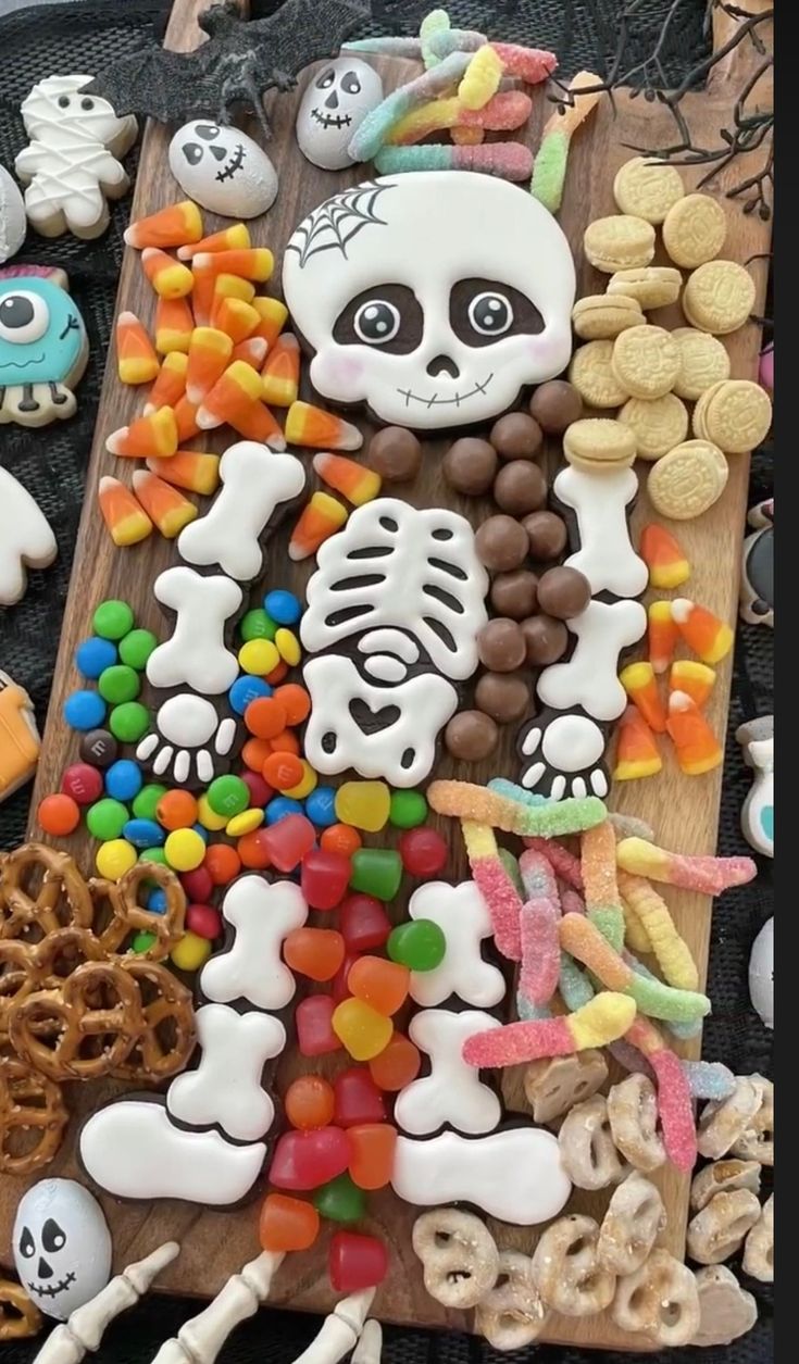 Playful Skeleton Icing Cookies Surrounded by Colorful Halloween Treats.