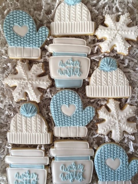 Cozy Winter Cookie Designs: Mittens, Snowflakes, and Knit Hats in Soft Blue and White.