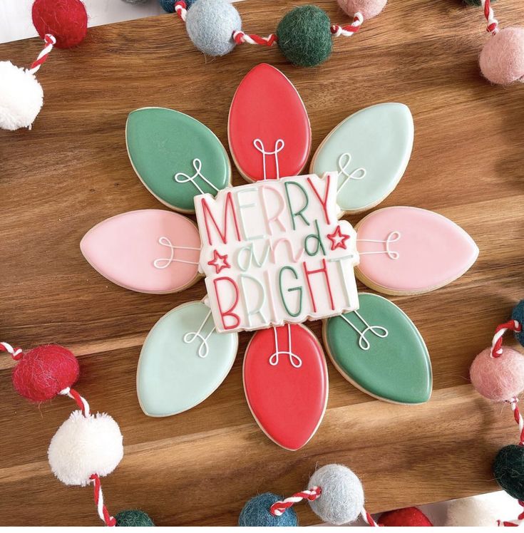 Vibrant Flower-Shaped Holiday Cookie Design with Festive Colors and Playful Lettering.