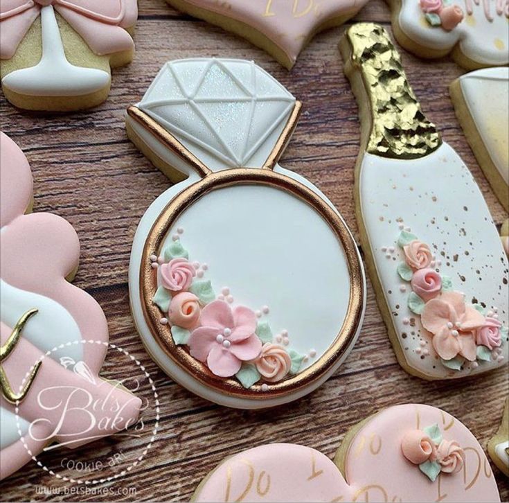 Elegant Intricate Cookie Designs for Weddings: Diamond Ring and Champagne Bottle in Pastel Colors.