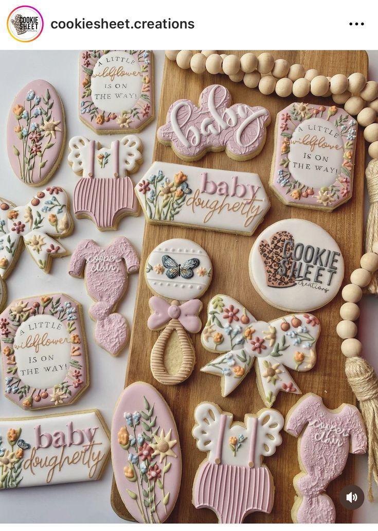 Charming Floral and Baby-Themed Decorated Cookies in Pastel Colors for Special Occasions.