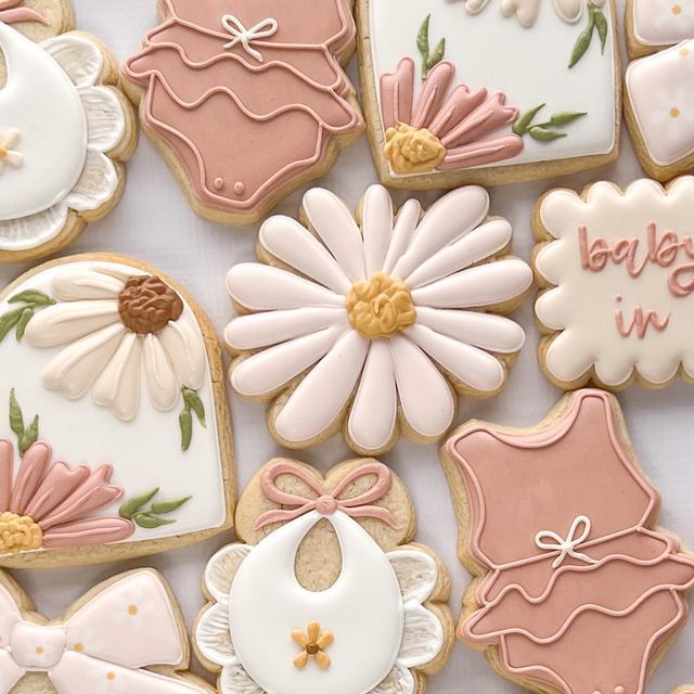 Charming Whimsical Cookies: Delicate Floral and Baby-Themed Designs for Celebrations.