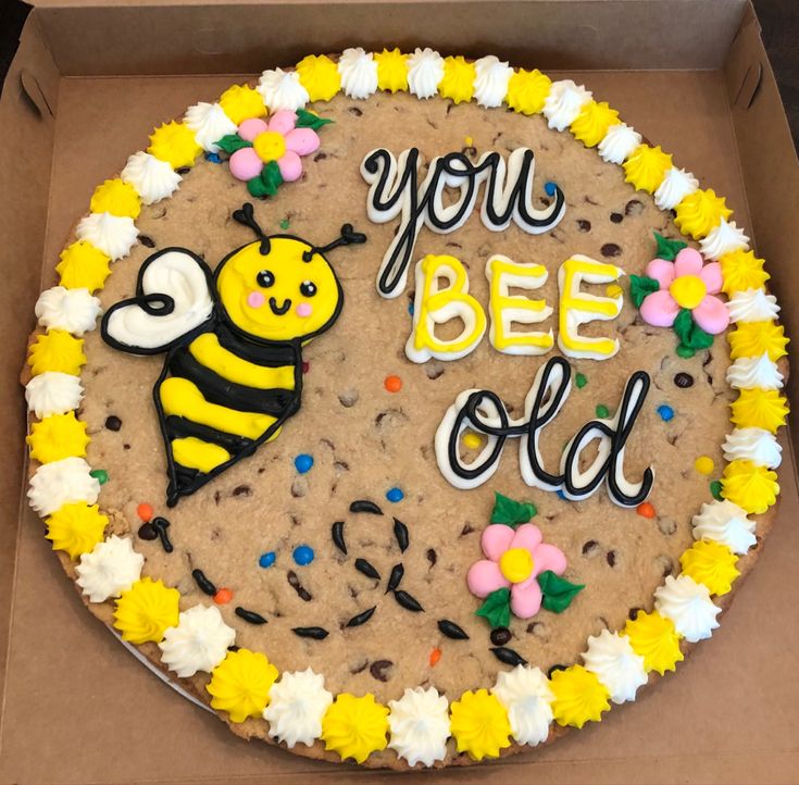 Vibrant and Whimsical Bee-Themed Cookie Cake with Floral Accents.