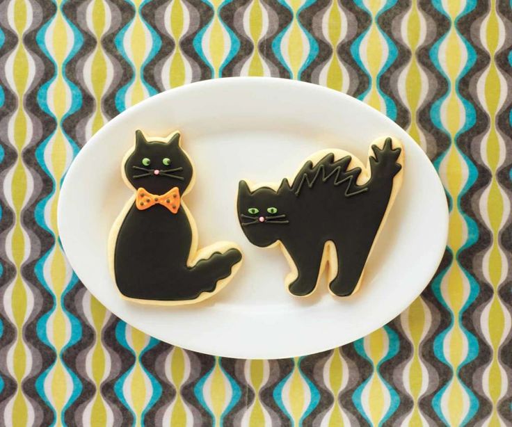 Playful Cat-Themed Cookies on a Striking White Plate with Retro Background.