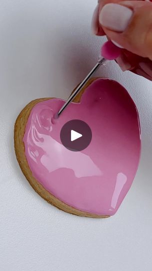 Vibrant Heart-Shaped Cookie with Glossy Pink Icing and Artistic Detailing for Special Occasions.