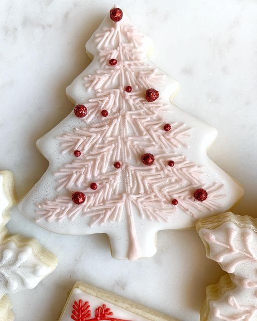 Festive Christmas Tree Cookie Design with Soft Pink Frosting and Red Accents