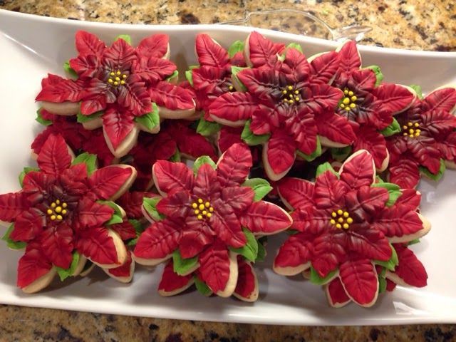 Elegant Decorative Poinsettia Cookies: Festive Treats with Lifelike Icing Details.