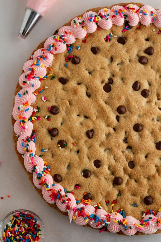 Vibrant Cookie Cake with Pink Frosting, Chocolate Chips, and Sprinkles: A Whimsical Celebration Dessert.