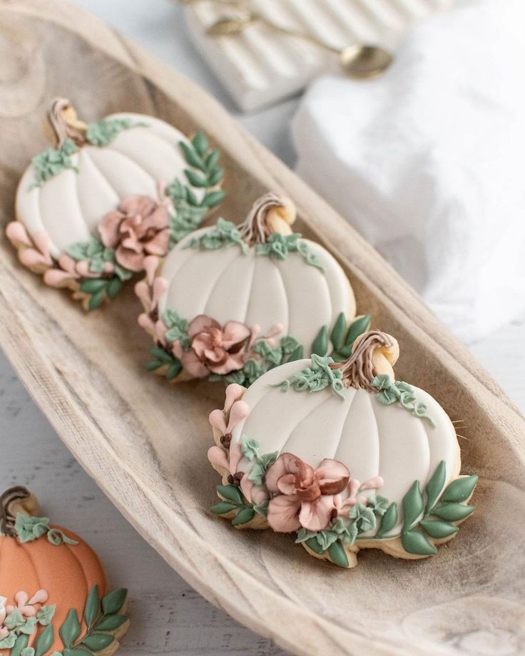 Charming Pumpkin-Themed Cookies with Floral Decorations and Rustic Presentation.