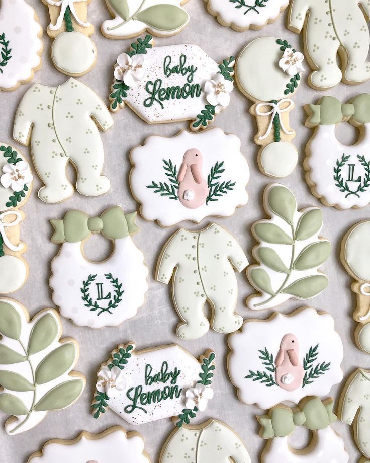 Whimsical Pastel Decorative Cookies: Adorable Baby Onesies and Floral Designs with Intricate Icing Details.