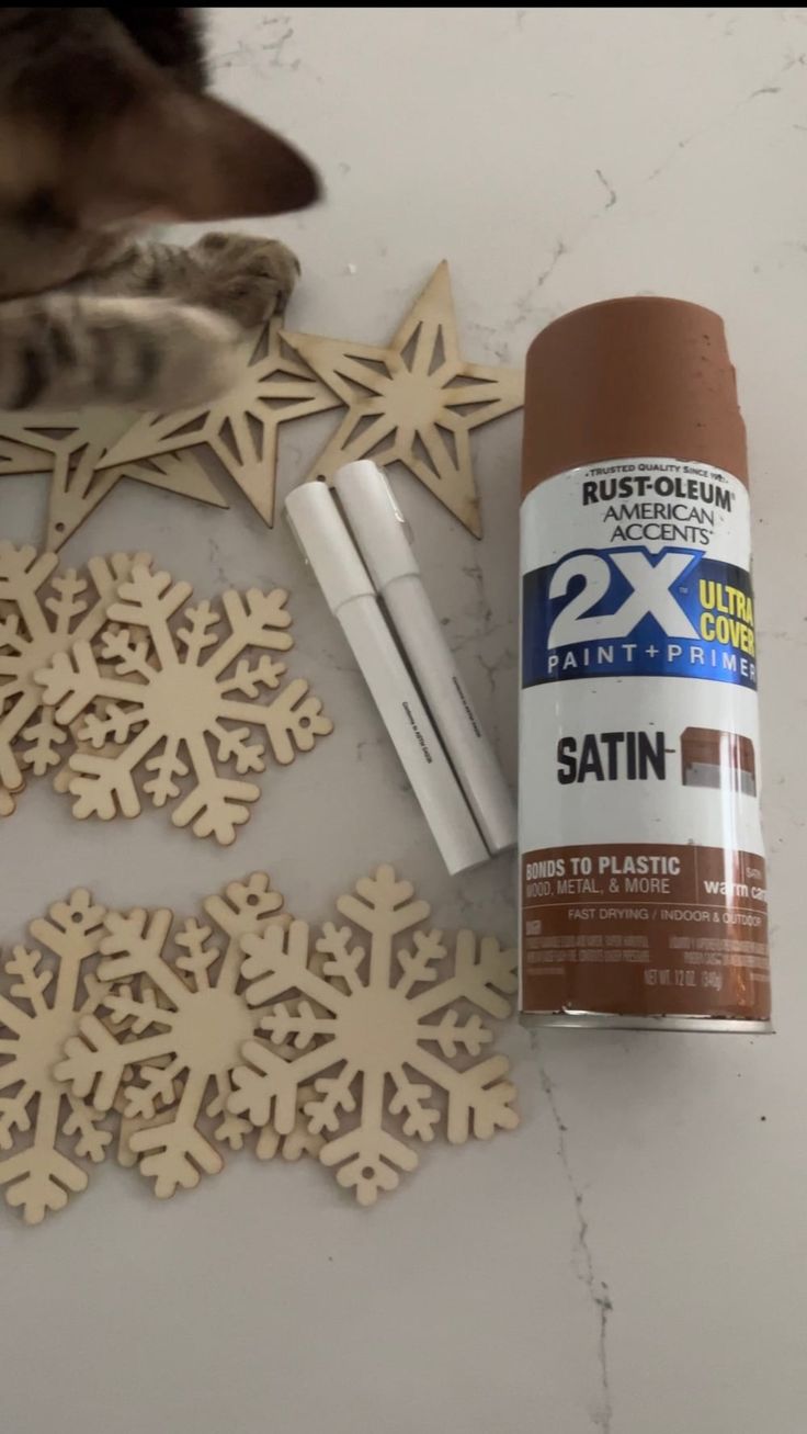 Festive Artistic Supplies for Personalized Holiday Decorations: Wooden Snowflakes, Star Shapes, Spray Paint, and Markers.