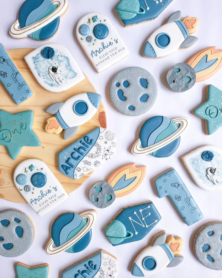 Charming Celestial Cookie Designs: Playful Planet, Rocket, and Star Shapes in Soothing Colors