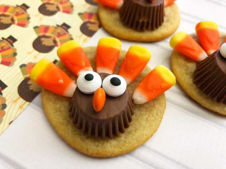 Adorable Festive Turkey Cookies: Whimsical Designs with Chocolate Cups, Candy Corn Feathers, and Delightful Candy Eyes.