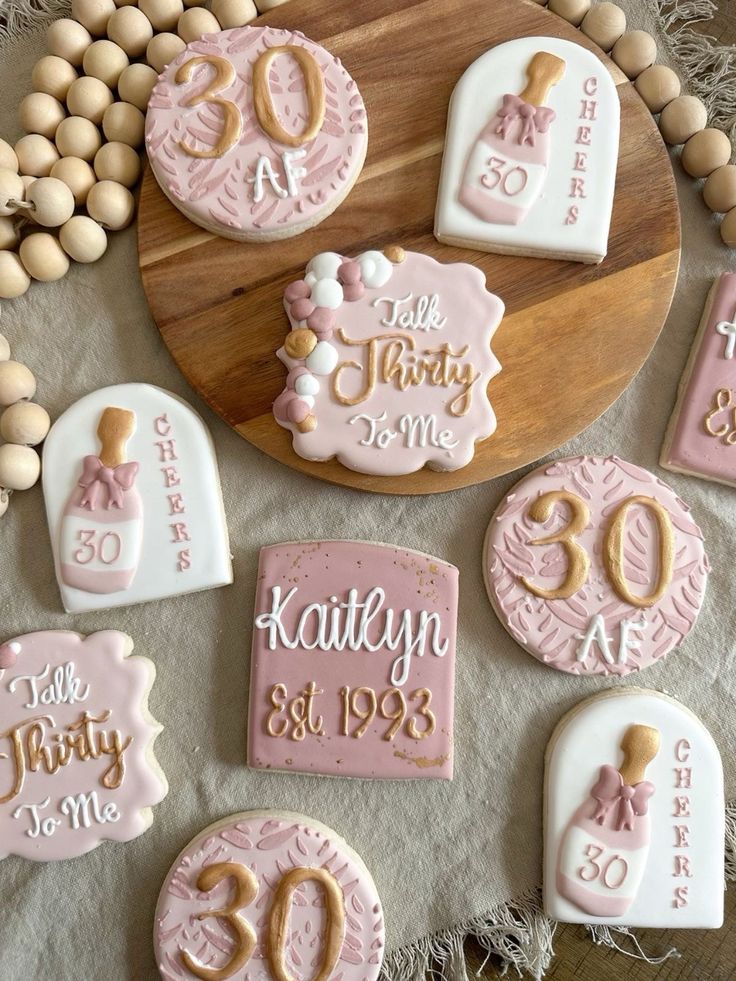 Charming Milestone Birthday Cookies: Elegant Pink and White Designs as Festive Treats and Decor.